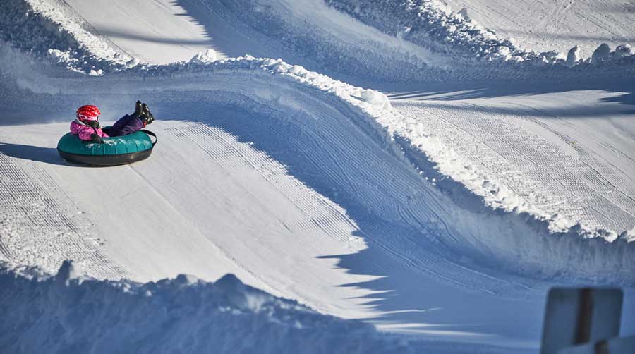 A girl snow tubing in Arapahoe Basin