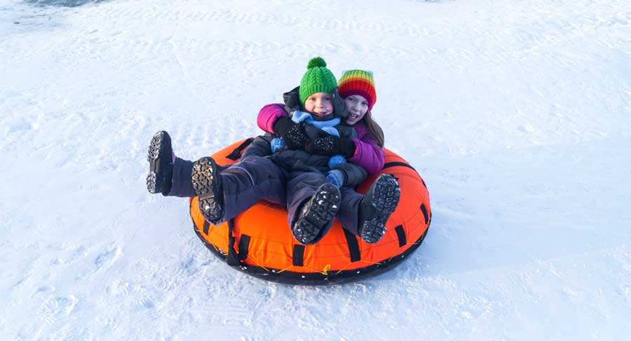 Two kids enjoying their snow tubing activity in Keystone
