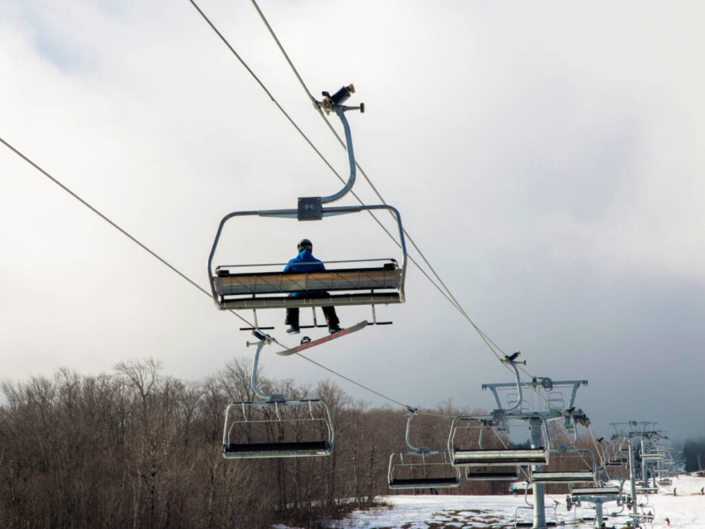 A snowboarder on a ski lift ride