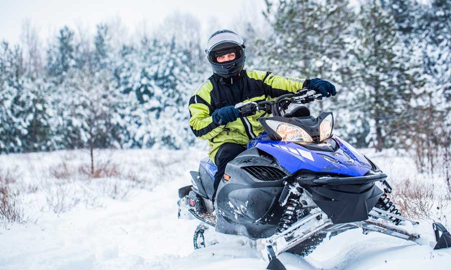 A man riding his snowmobile in Vail, Colorado