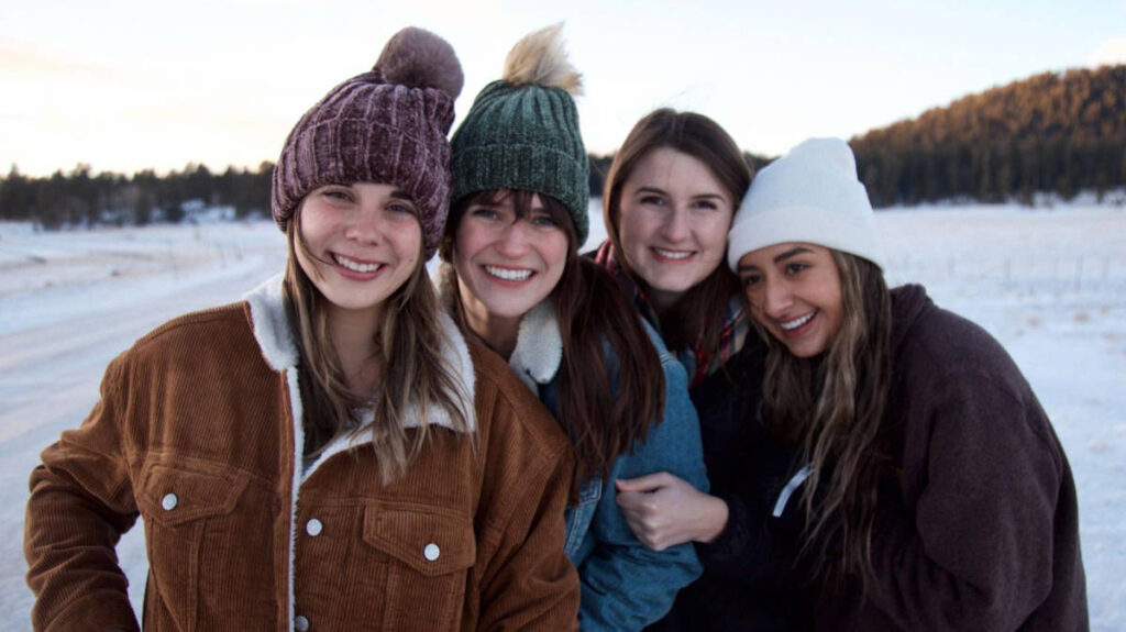 The author Betty Hurd with her friends smiling for a photo during a snowy day