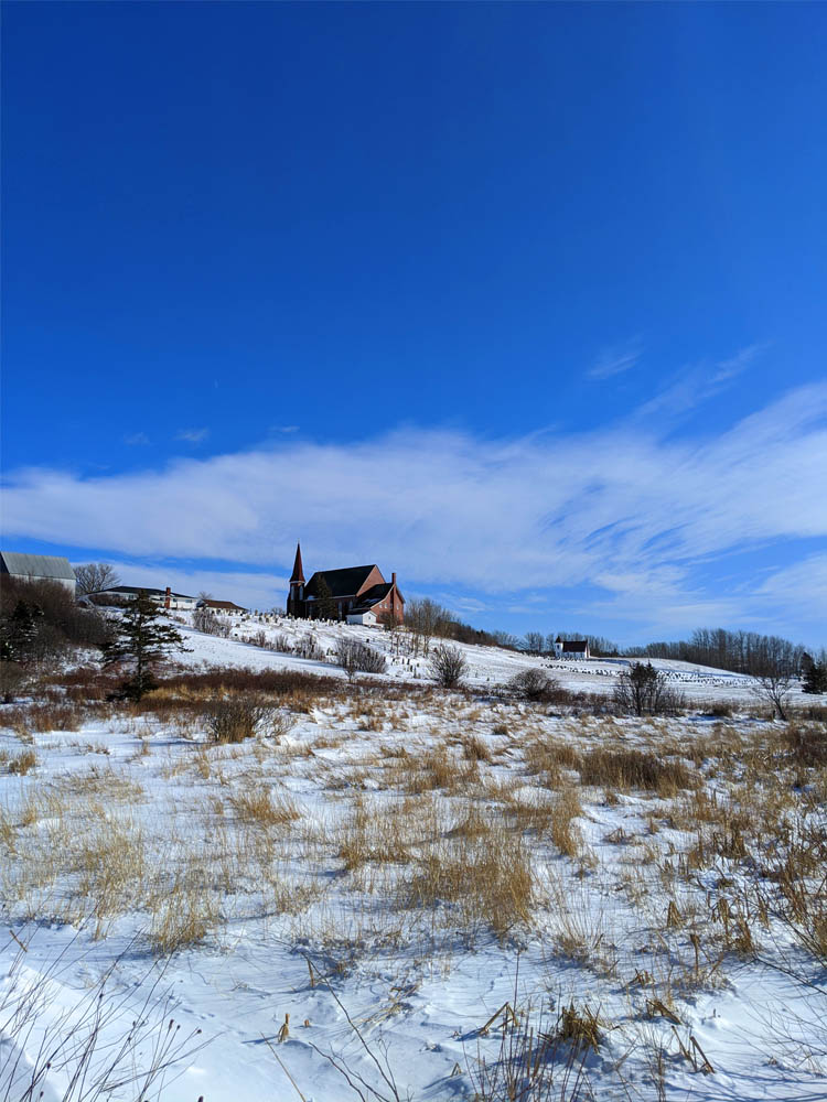 A tranquil snowy landscape features a distant house