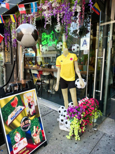 A mannequin wearing a soccer uniform with other decors on the window bay of a restaurant
