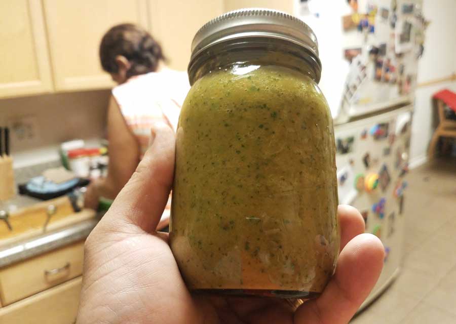 A hand holding a sofrito on a jar