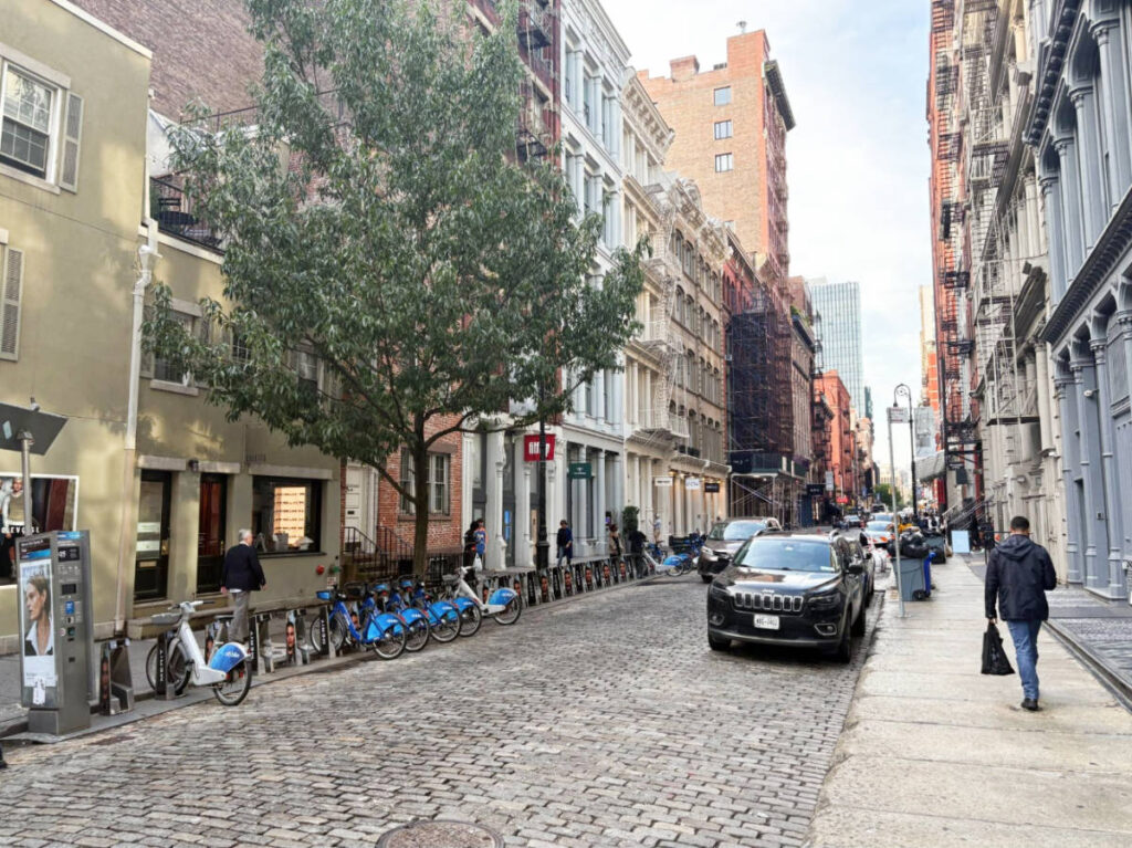 Bikes and cars parked on a street in the Soho neighborhood