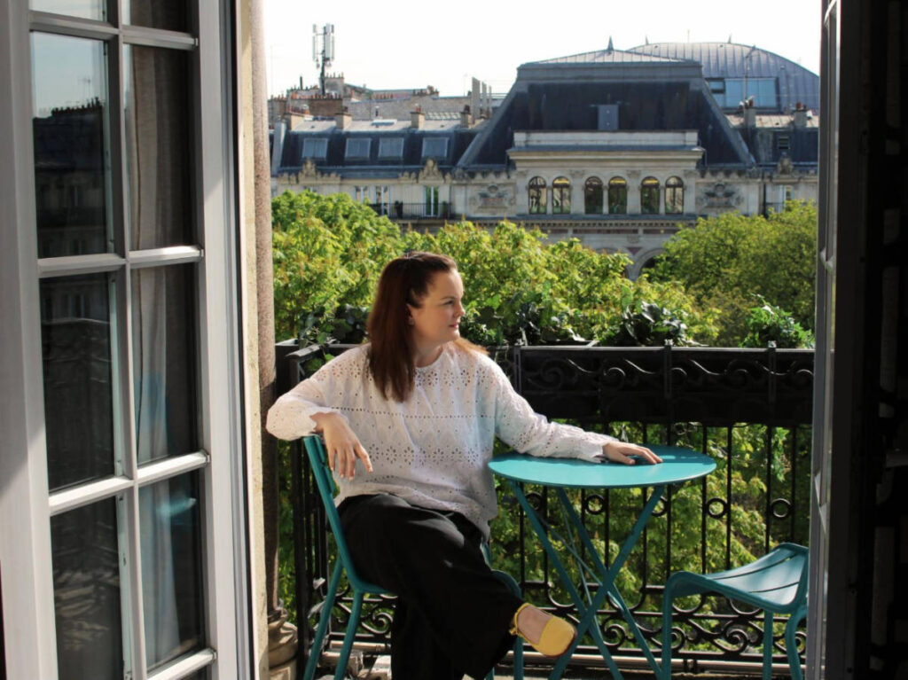 The author Rachel Kapelke-Dale admiring the view at the balcony of Solly Hôtel
