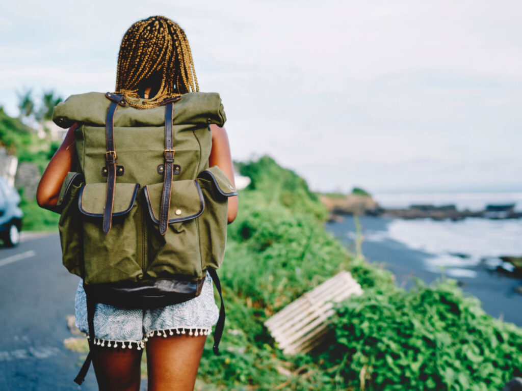 Back view of African American female tourist with backpack