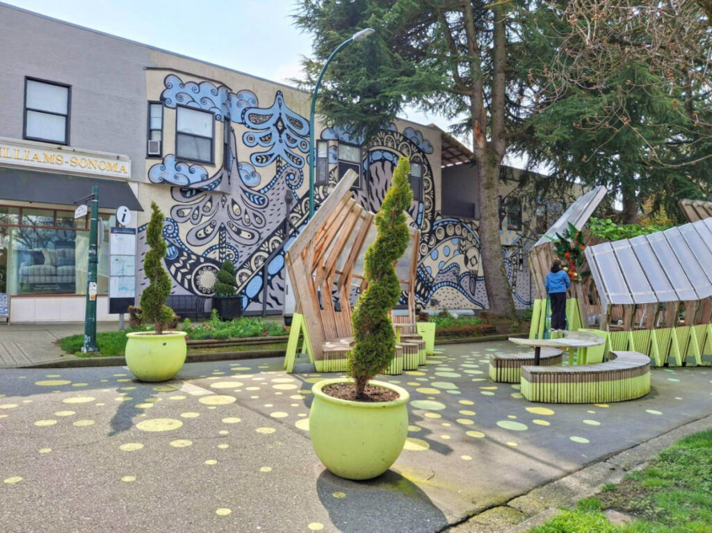 A mural on the wall and the greenery around the South Granville Plaza West