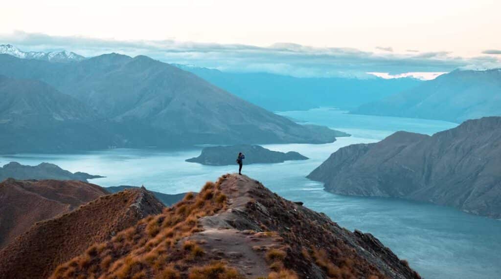 A woman on top of a mountain with an overlooking view of South Island