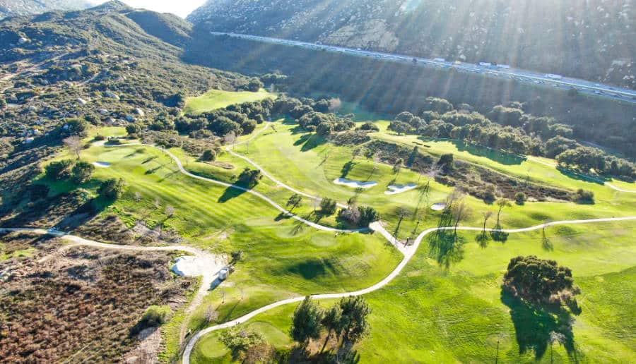 A sunny aerial view of the green landscape of a golf course