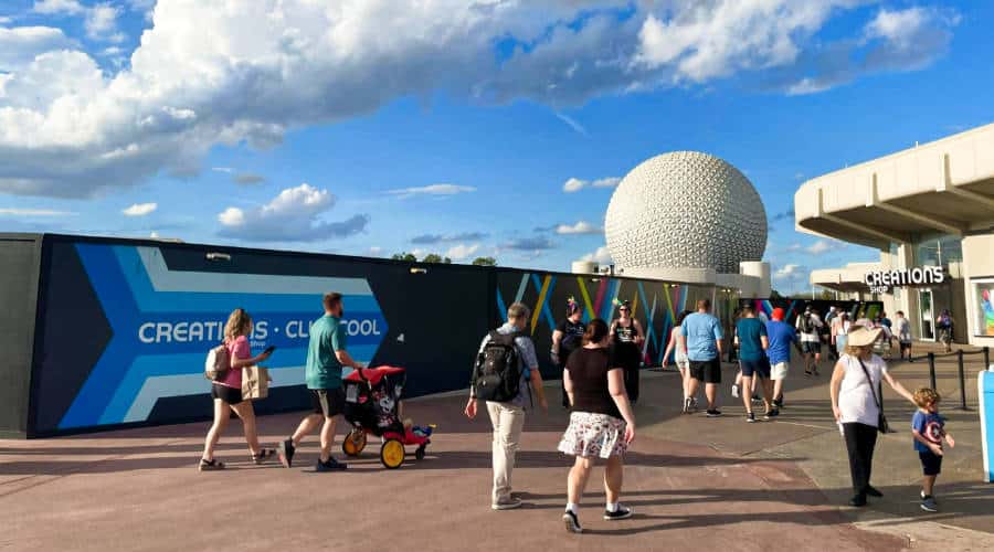 People walking around Walt Disney World Resort with the top view of Spaceship Earth at Epcot.