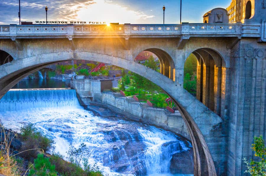 Sunrise over a concrete arched bridge and dam near Spokane Falls