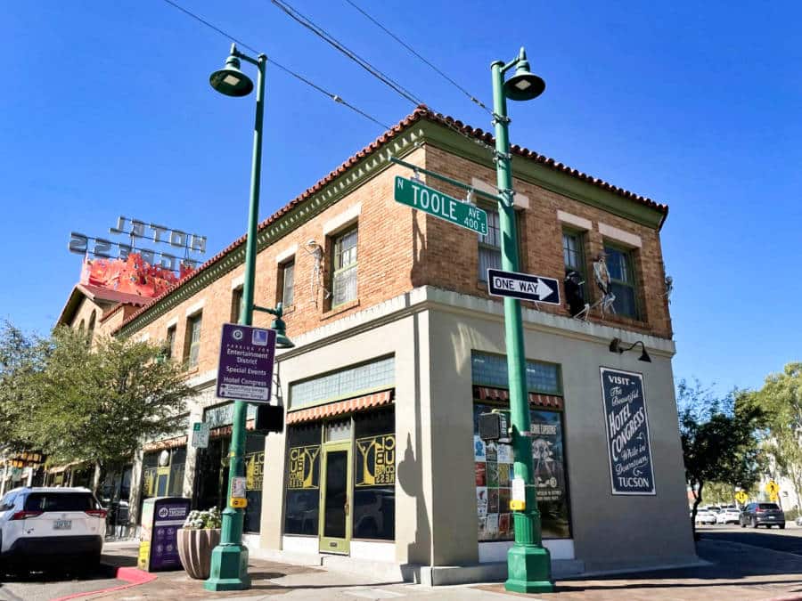 View of the shops at the corner street with road signs on the lamp posts