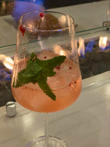 A glass of spritzer by the fireplace at The Deck at 264 Fresco