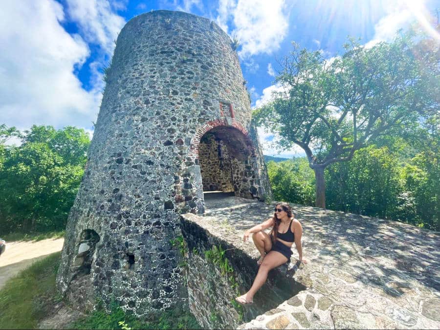 A woman posing at the ruins on St. John in the US Virgin Islands on a sunny day