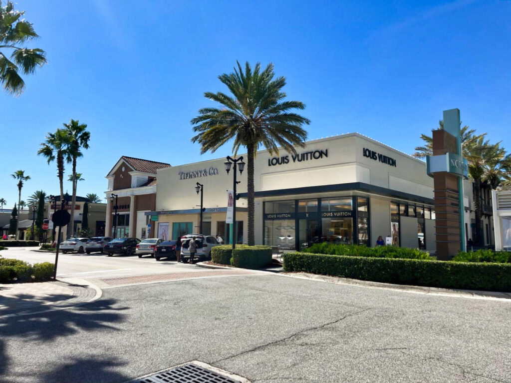 The storefront of the luxury shops seen from across the road on a sunny day