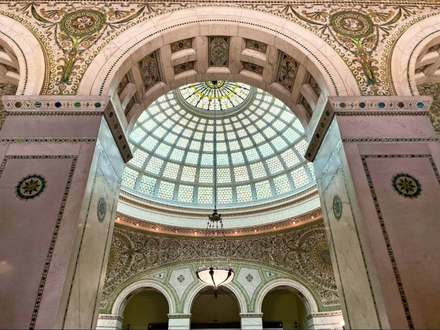 View of the largest Tiffany stained-glass dome between the pillars in the Chicago Cultural Center