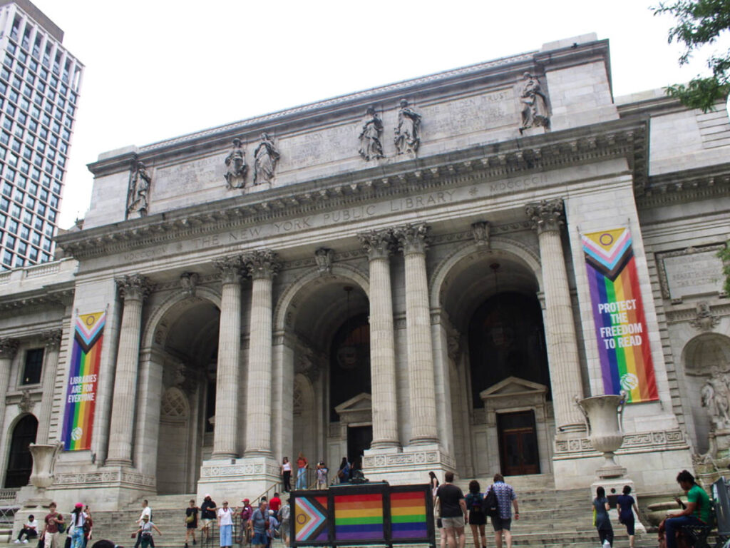 View of the staircase and Pride flags in front of the NY Public Library