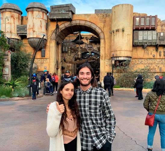 The author with her brother posing for a photo in front of Star Wars: Galaxy’s Edge land