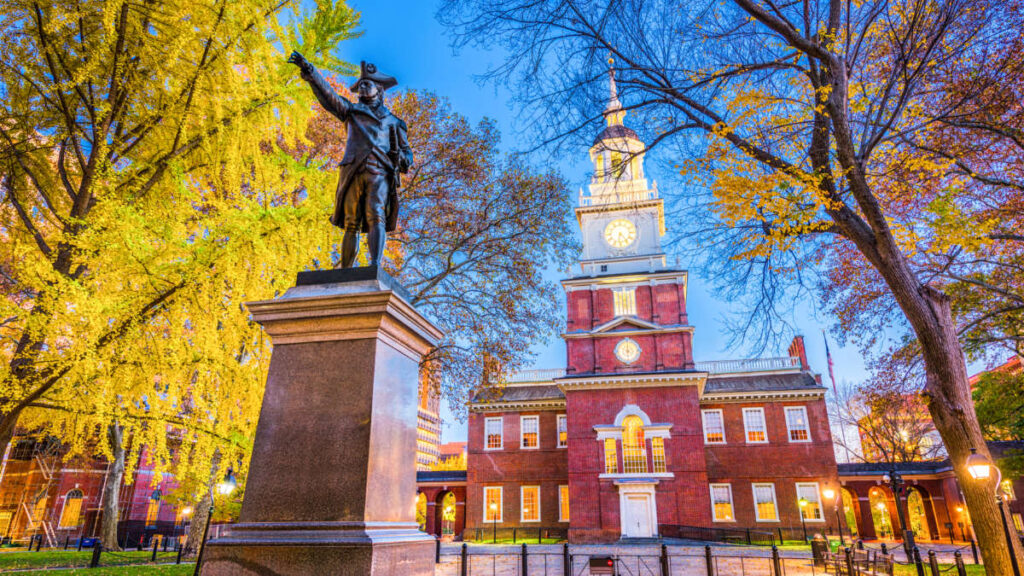 A statue in front of the Independence Hall in Philadelphia at dusk