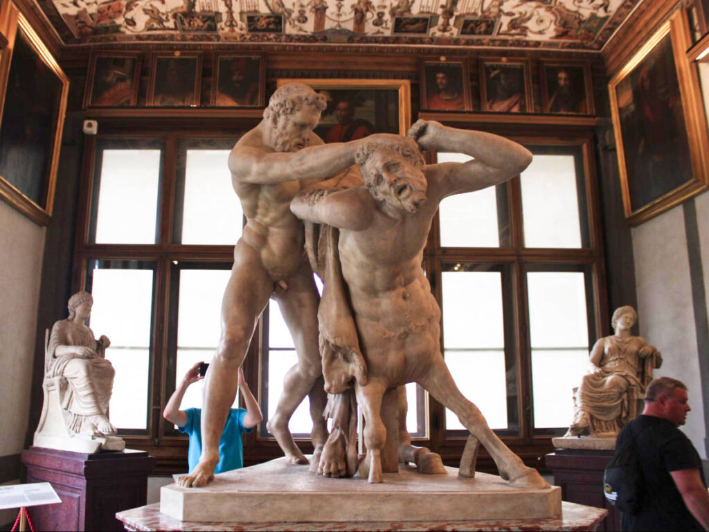 View of the people around the brawling statue in the middle of the museum