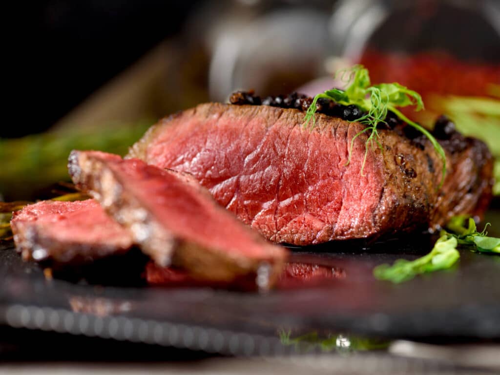 A rare steak on a wooden board served in Bazaar Meat By José Andrés