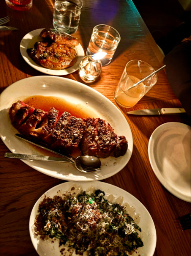A plate of sliced steak and different dishes at Straker’s