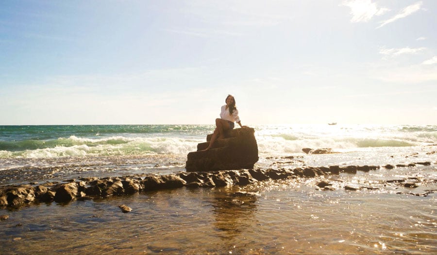 The author sitting on a steps in the shore of Steps Beach