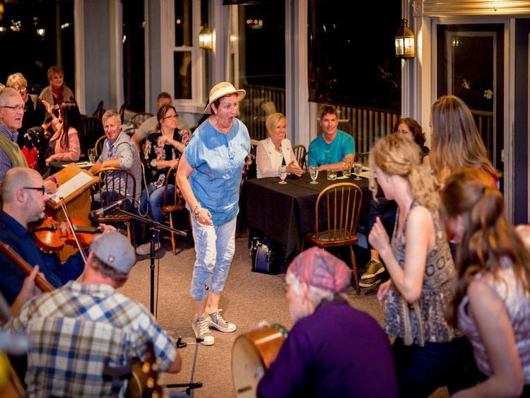 People having fun with musical band and woman in blue dress at center in Nova Scotia