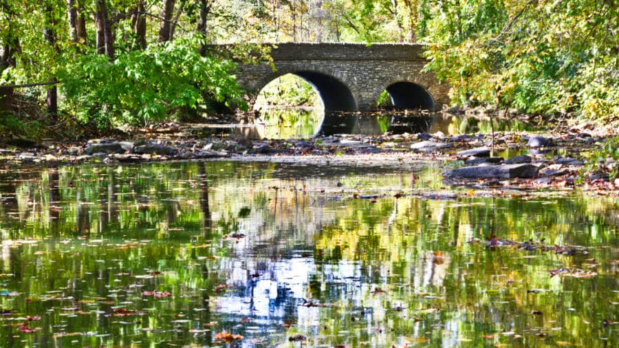 View of the stone bridge reflected on the stream in Sharon Woods