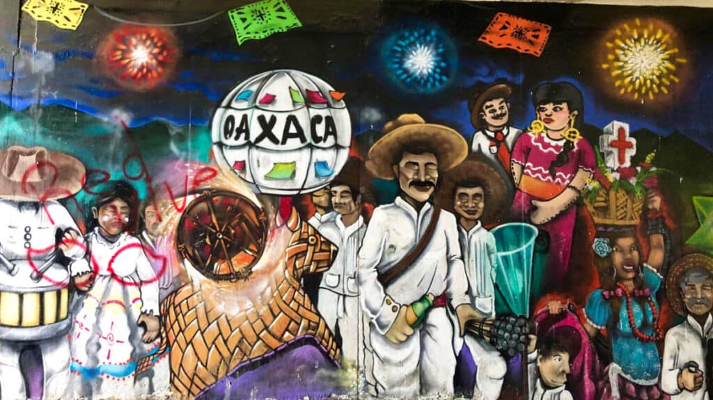 A wall with a colorful mural of the diverse culture of Oaxaca