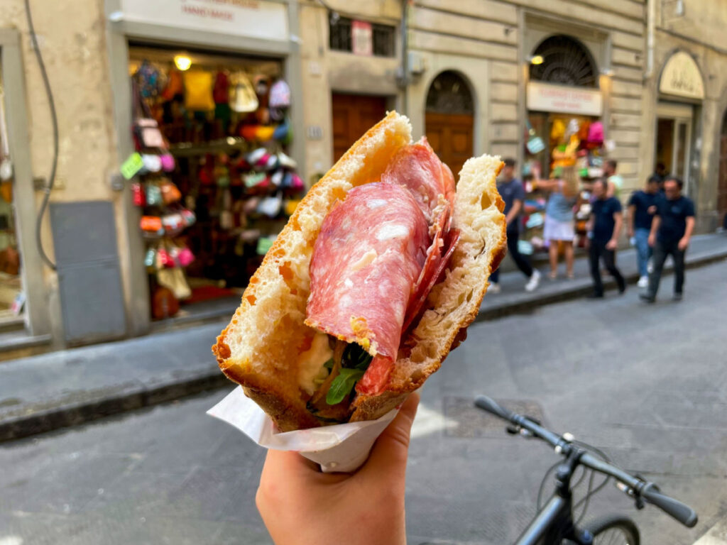 Traditional Florentine street food Sandwich with Schiacciata bread, Salami slices and rocket salad