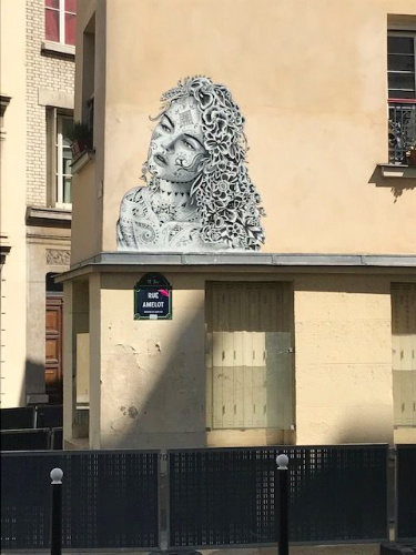 Street art mural of a woman's face on the side of a building in the 11th district