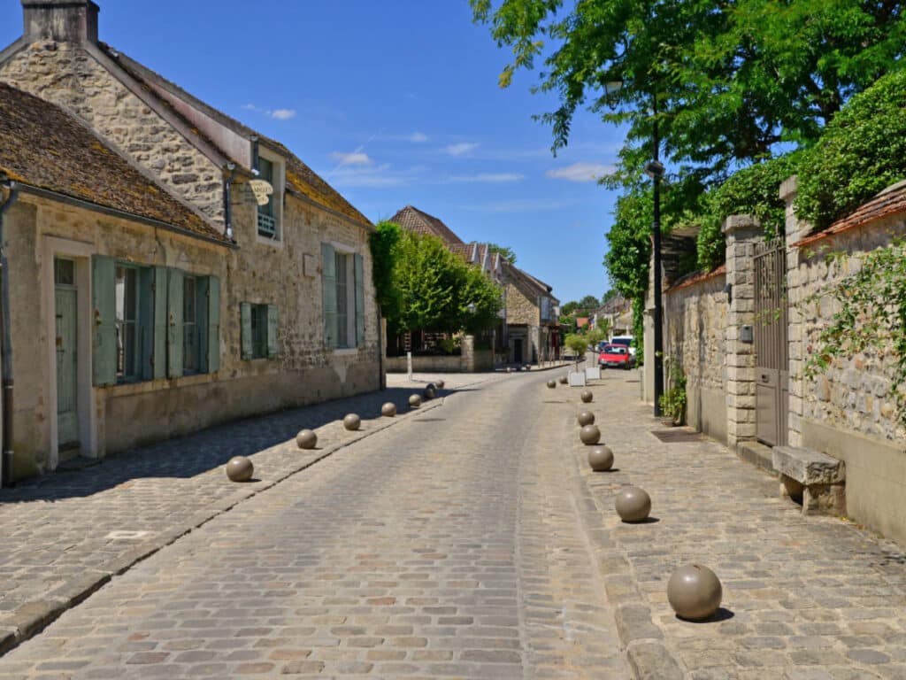 Clear blue sky over a cobbled street at the Barbizon