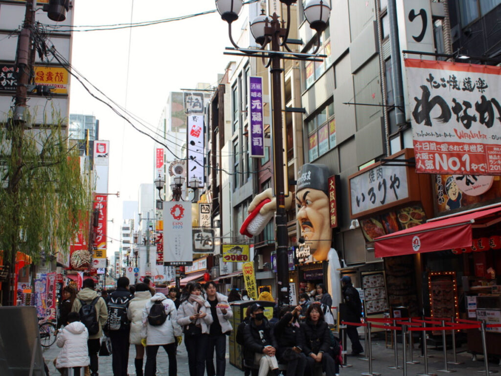 Street scene in Dotonbori, teeming with crowds and lively atmosphere