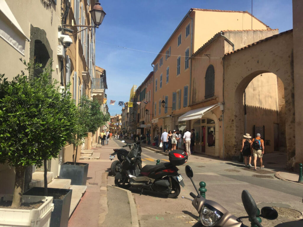 Street in Saint-Tropez's Old Town, filled with numerous people in the sidewalks