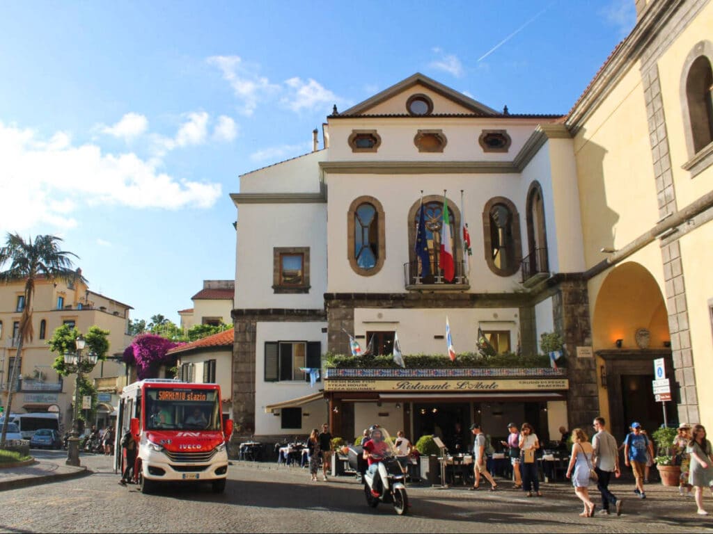 A red bus and the people wandering around the busy Sorrento