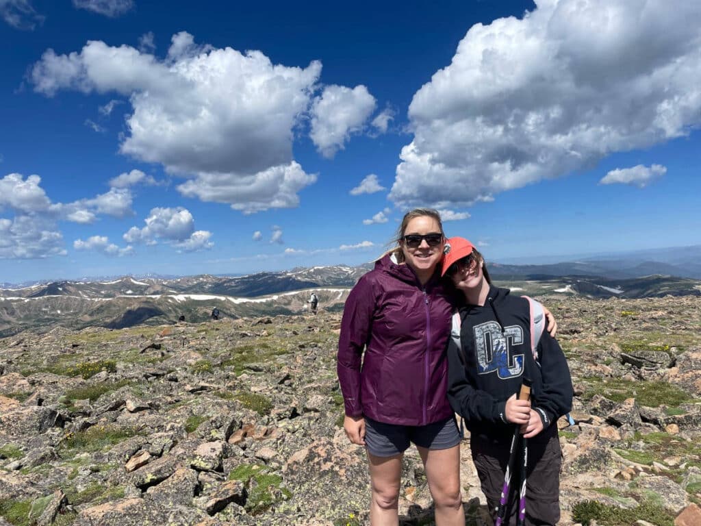 Travel Lemming writer Laura Falin and her daughter posing at the summit of Mt. Flora on a sunny day