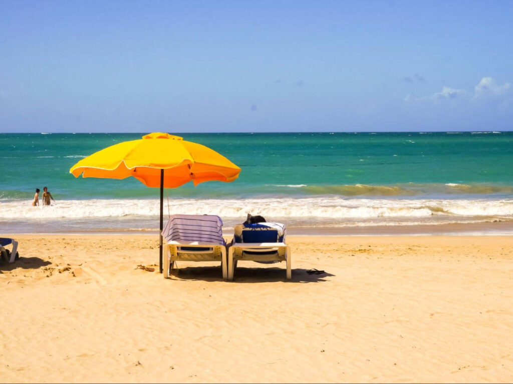 People swimming and sunbathing at the beach on a sunny day