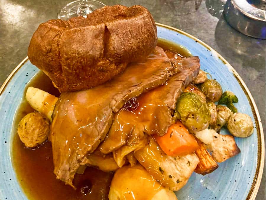 A plate with a big serving of roast beef with vegetables