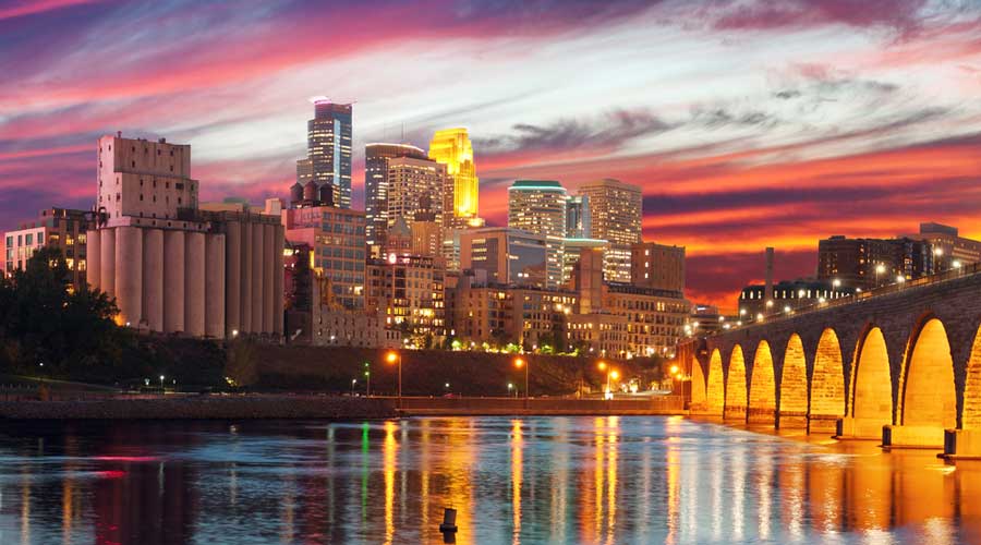 View of the skyscrapers and Stone Arch Bridge in Downtown Minneapolis during sunset