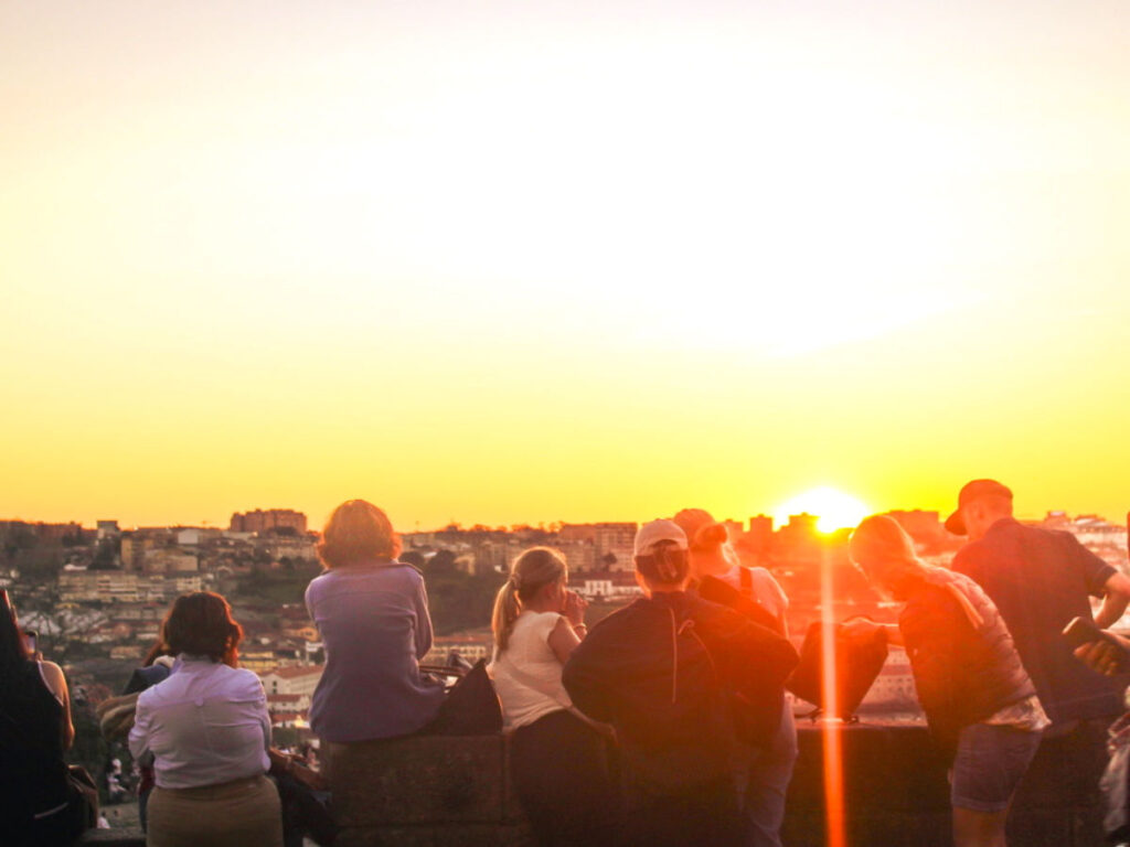 Group of friends watch the sunset at Miradouro da Serra do Pilar