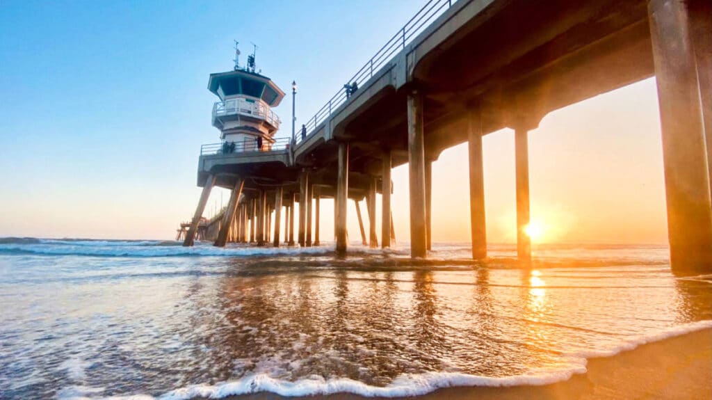 View of the beach pier from the shore during sunset