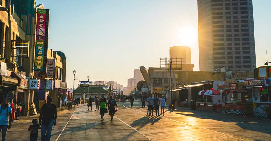 People walking at the Atlantic City Boardwalk during sunset
