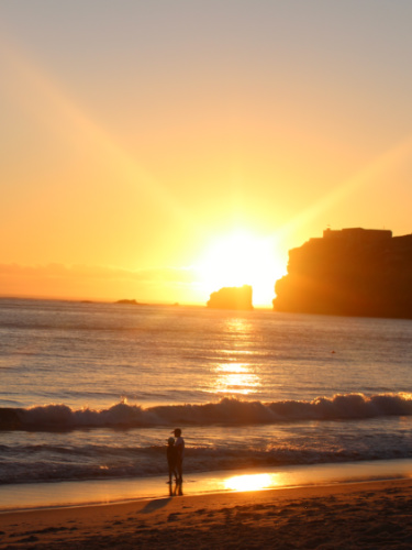 The children enjoying the sunset views from the shoreline of Praia da Nazaré