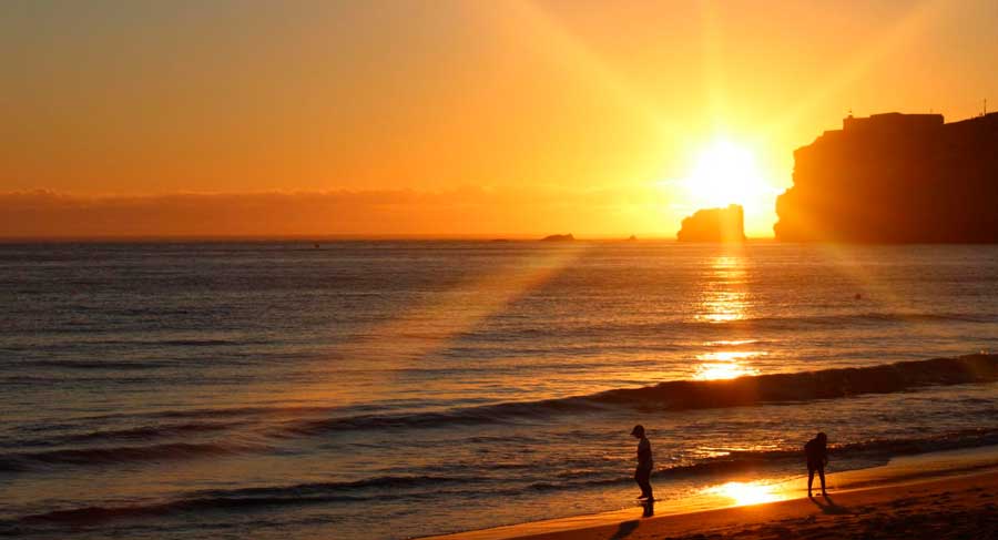 People on a beach during sunset
