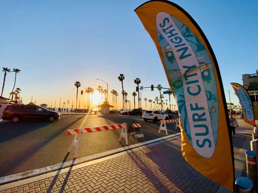A Surf City Nights flag during sunset in the Huntington Beach