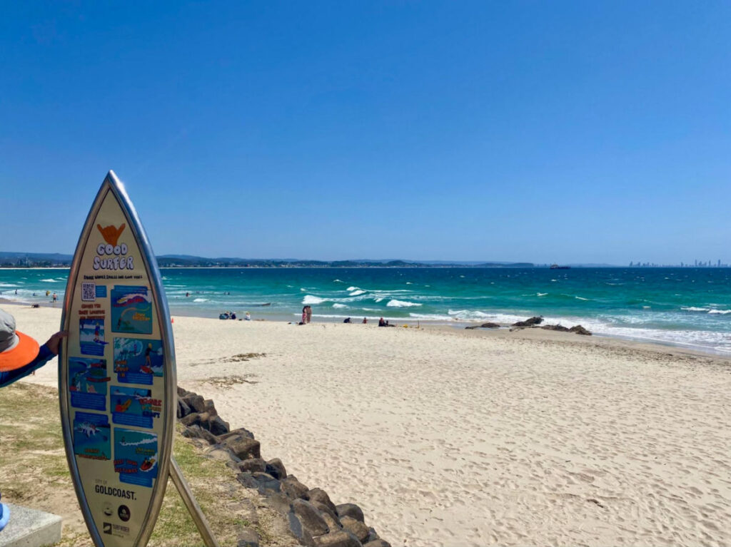 A surfboard shaped sign with activities in Coolangatta