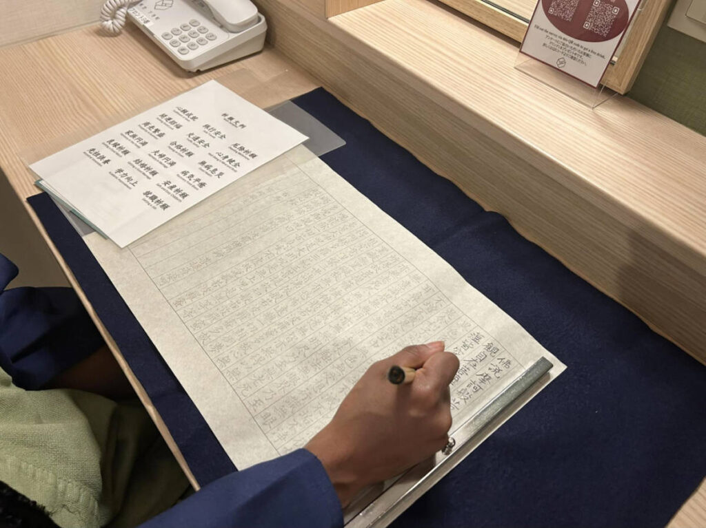 The author Chelsea doing the sutra copying