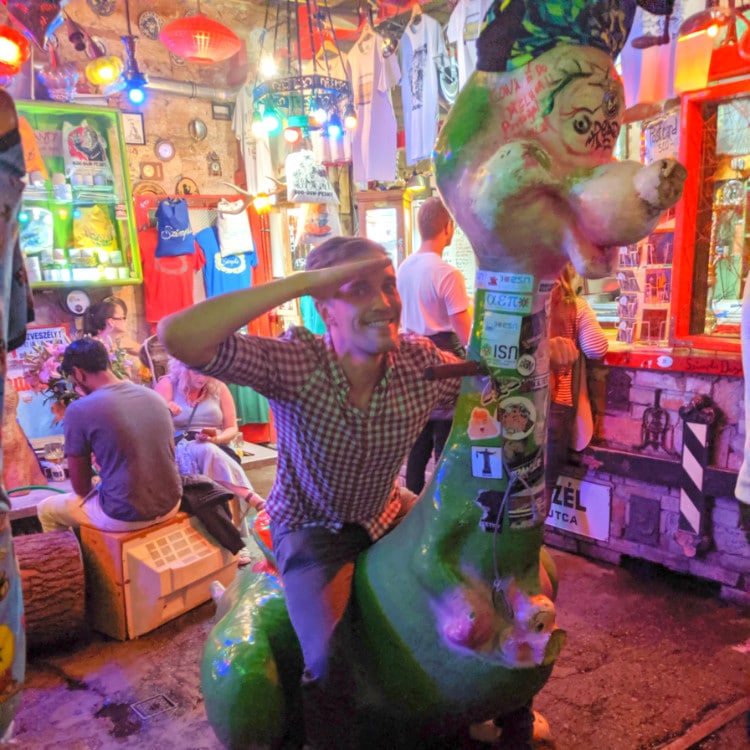 The author Nate Hake inside a colorful room at Szimpla Kert